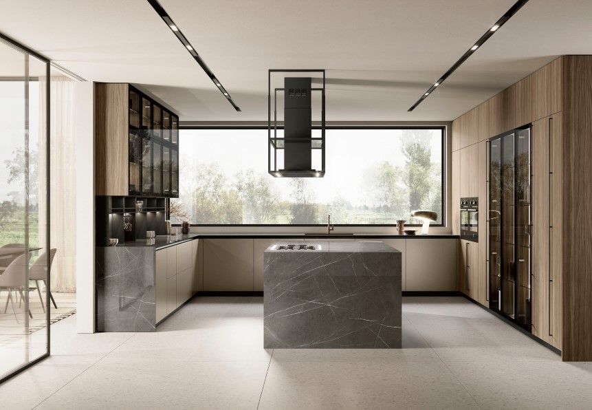 Cucina moderna con isola, ripiani in marmo, mobili in legno e ampia finestra con vista sugli alberi.