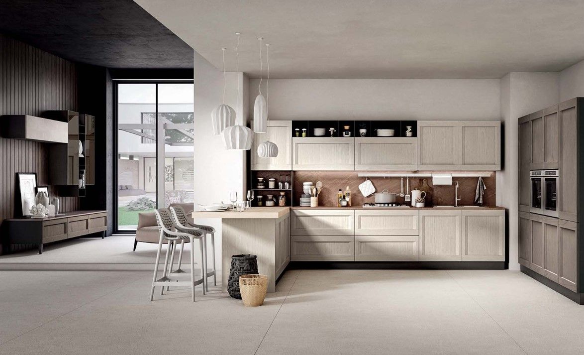 Cucina moderna con mobili in legno chiaro, sgabelli da bar e ampia finestra.