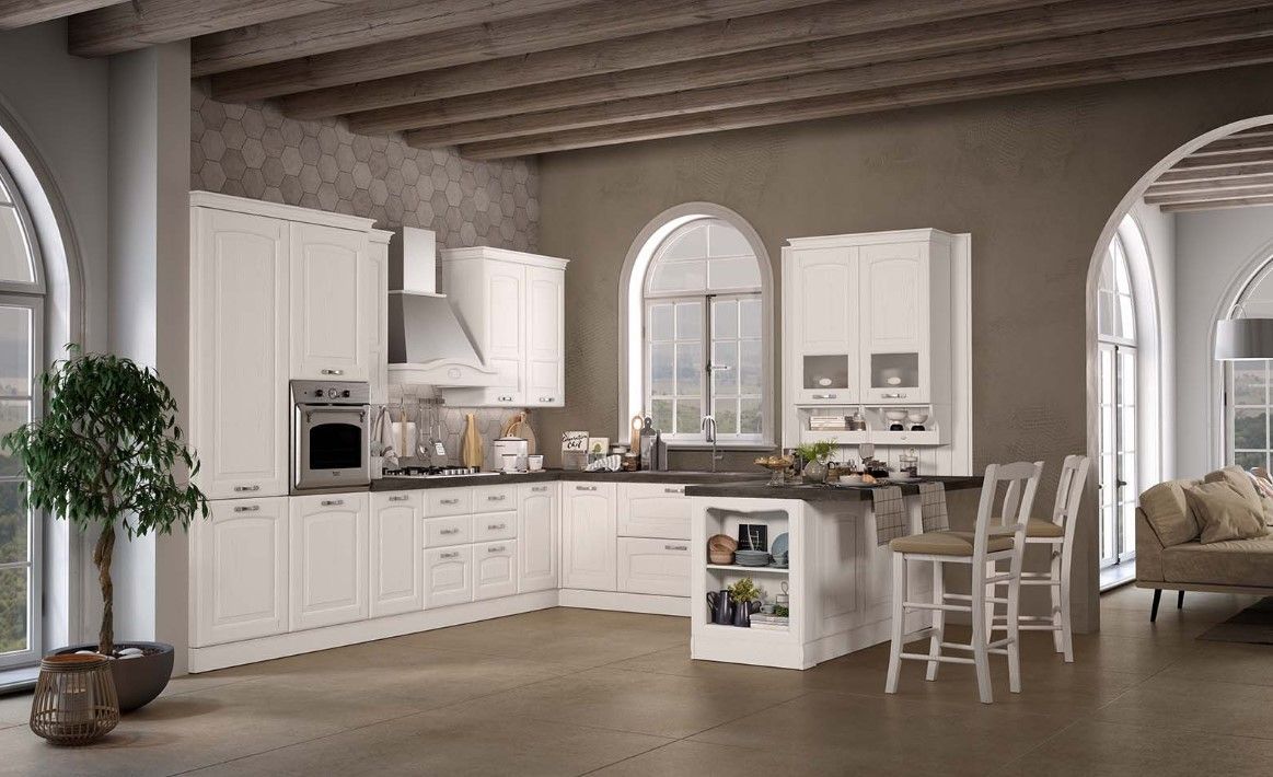 Cucina color crema con finestre ad arco, soffitto in legno e una piccola isola con sgabelli da bar.
