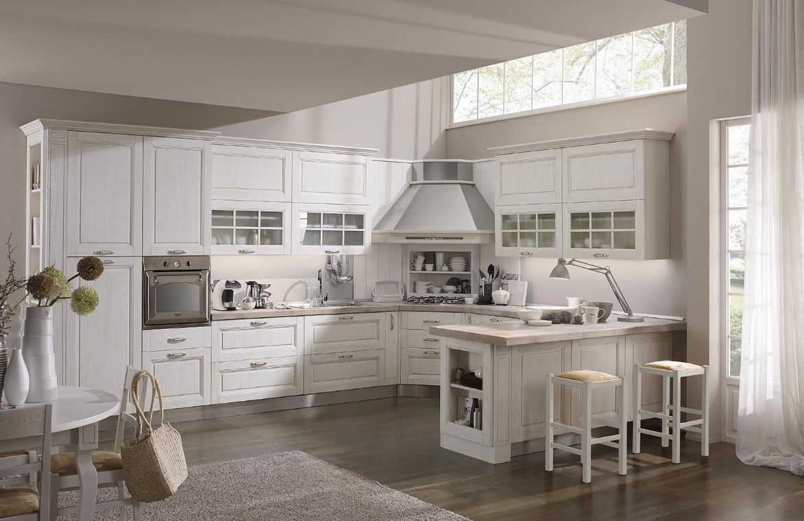 Cucina bianca con mobili, isola, forno e finestra.