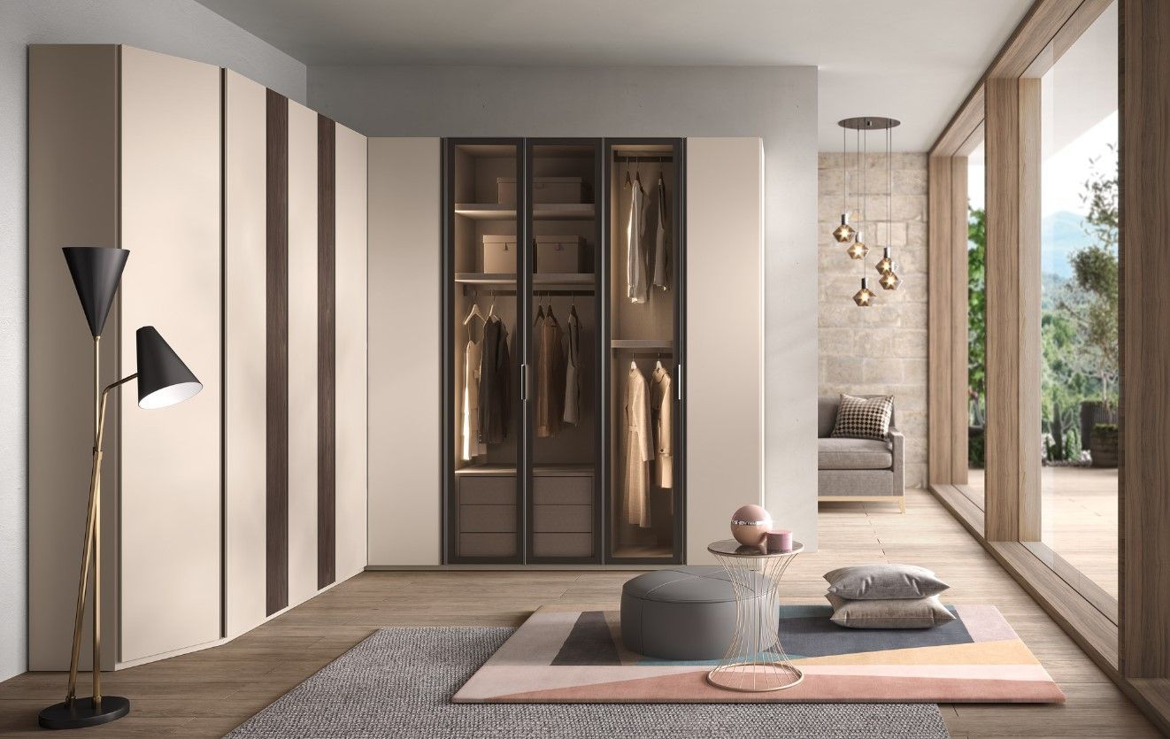 Moderna camera da letto con ampio armadio, porte in vetro e zona salotto con vista sul paesaggio naturale.