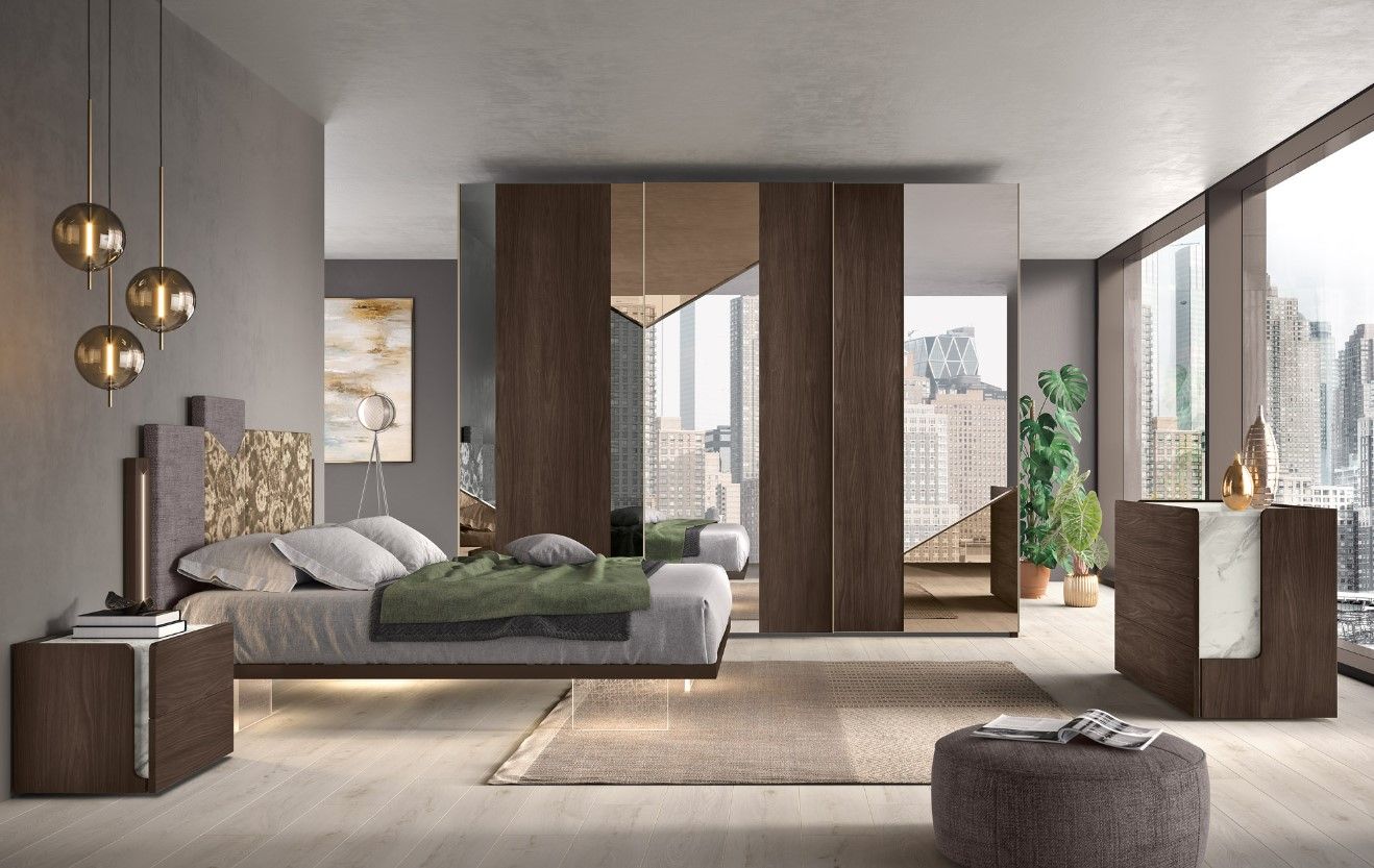 Camera da letto moderna con ampie finestre, colori neutri, letto, comodini e armadio a muro con ante a specchio.