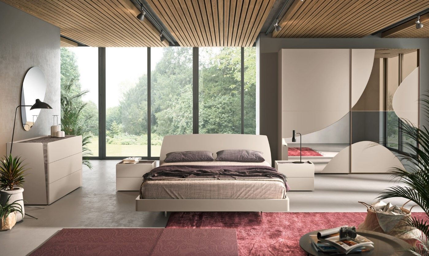 Camera da letto moderna con letto, cassettiera, comodini, ampia finestra con vista sugli alberi e soffitto rivestito in legno.