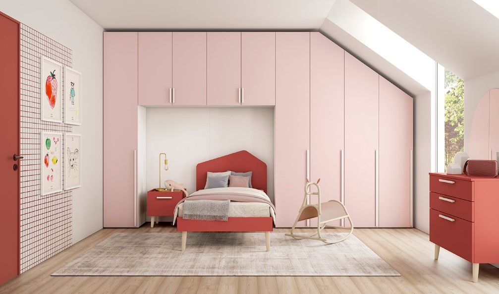 Camera da letto rosa e corallo con letto, armadio e cassettiera. Opere d'arte alla parete.
