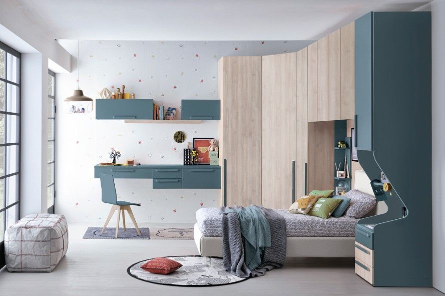 Camera da letto moderna con mobili nei toni del blu e del legno, tra cui scrivania, letto e armadio. Una finestra e dettagli decorativi completano l'ambiente.