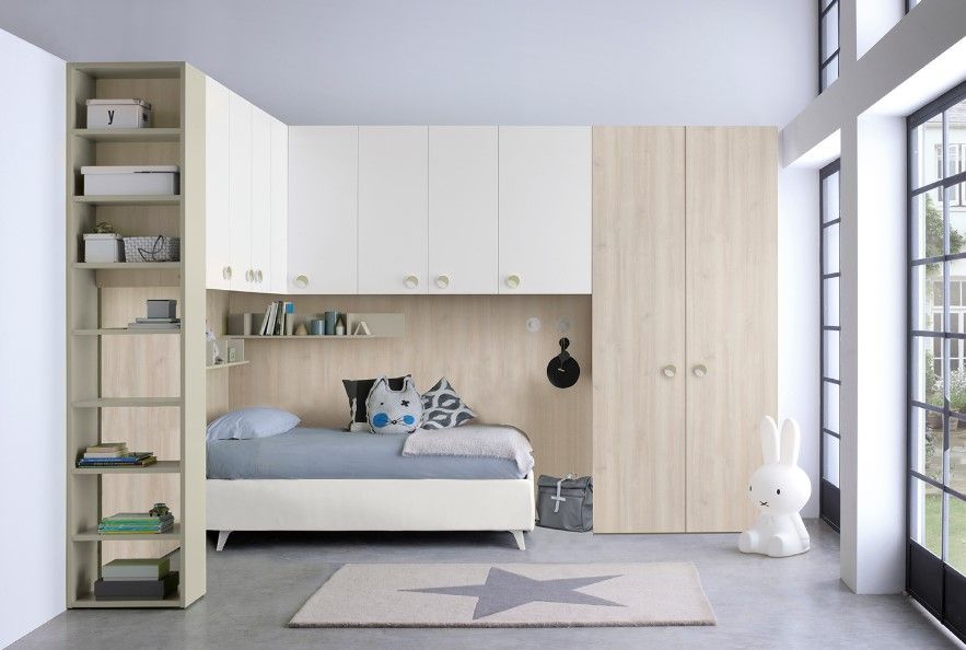 Camera da letto moderna con letto, armadietti, libreria e ampia finestra.