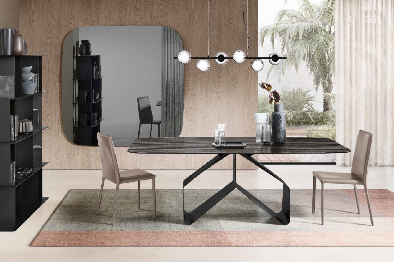 Sala da pranzo con tavolo, sedie, specchio e mobiletto. Toni neutri e arredamento moderno.