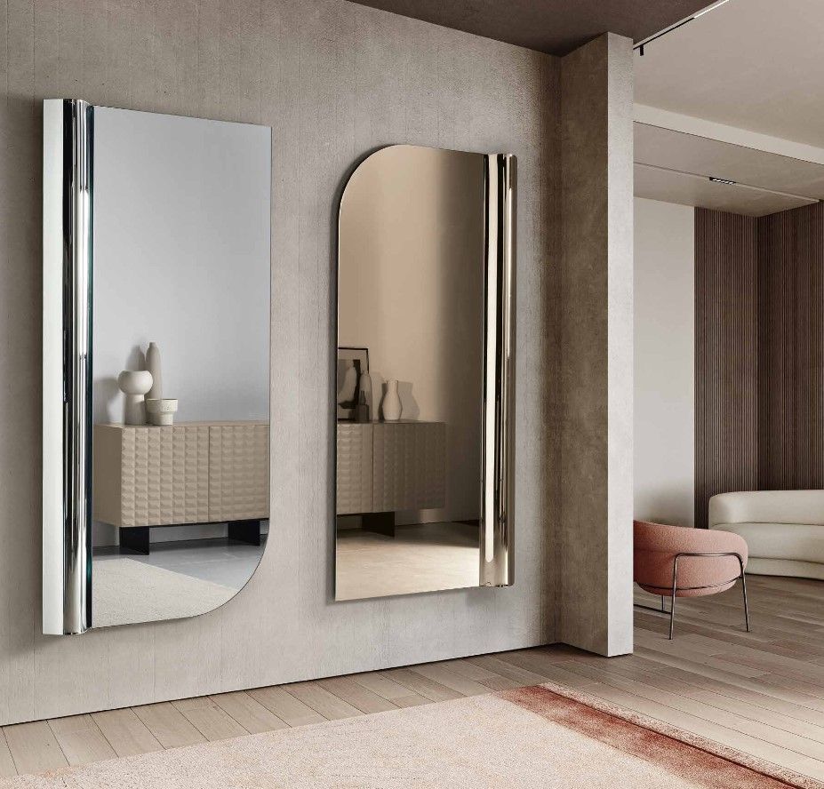 Due specchi decorativi su una parete: uno rettangolare e uno arcuato, con finiture argentate, in un ambiente interno moderno.