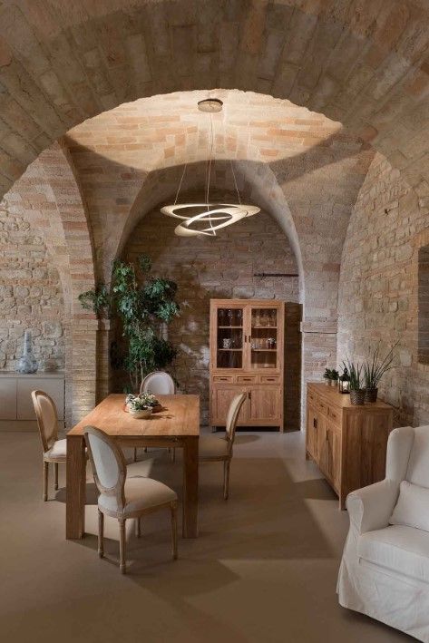 Sala da pranzo con mobili in legno e soffitto a volta in mattoni.