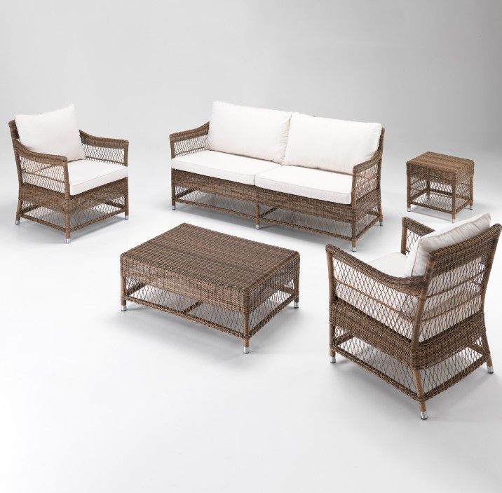 Set di mobili da giardino in vimini con divano, sedie, tavolino e tavolini laterali; marrone e bianco su sfondo bianco.