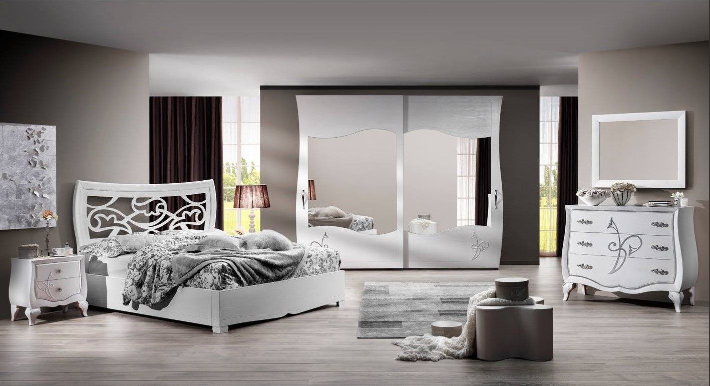 Camera da letto bianca con letto decorato, cassettiera, comodini e armadio.