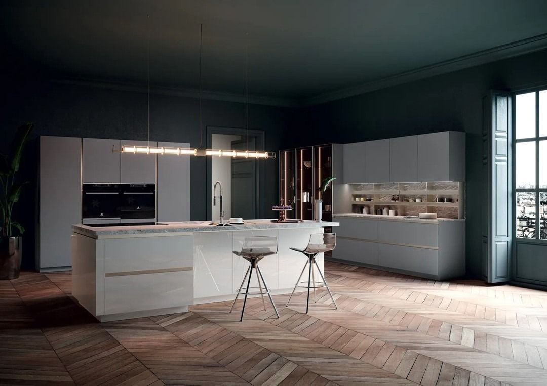 Cucina moderna con isola, mobili chiari, pareti verde scuro, pavimenti in legno e sgabelli da bar.