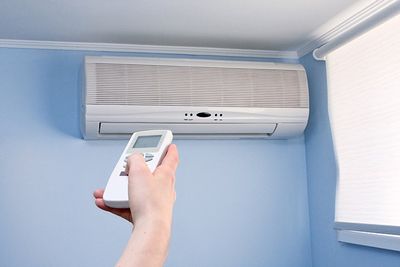Man using remote to control the heating and air conditioning