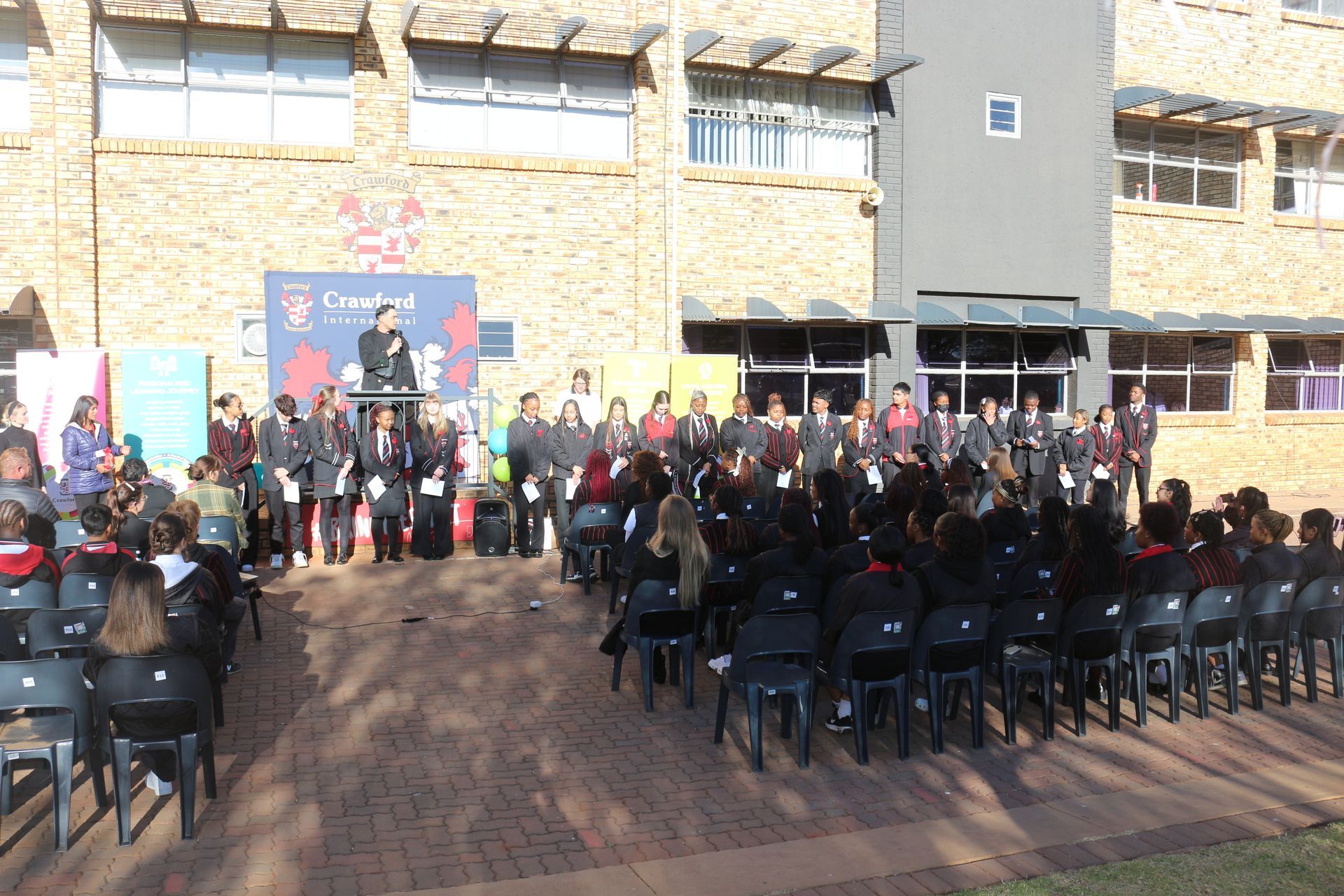 A large group of people are gathered in front of a large building