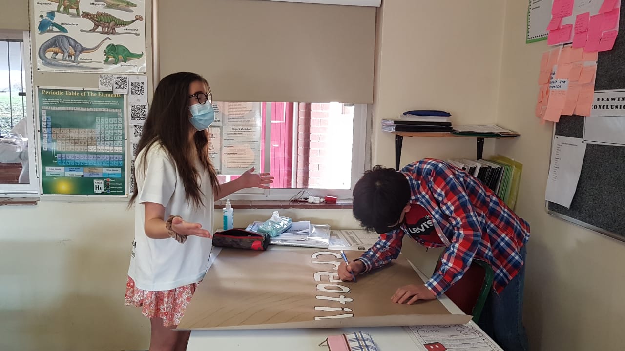 A man and a woman are working on a project in a classroom.