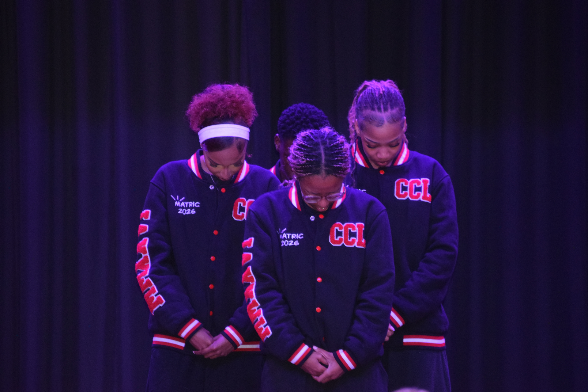a group of young girls are posing for a picture on a stage .