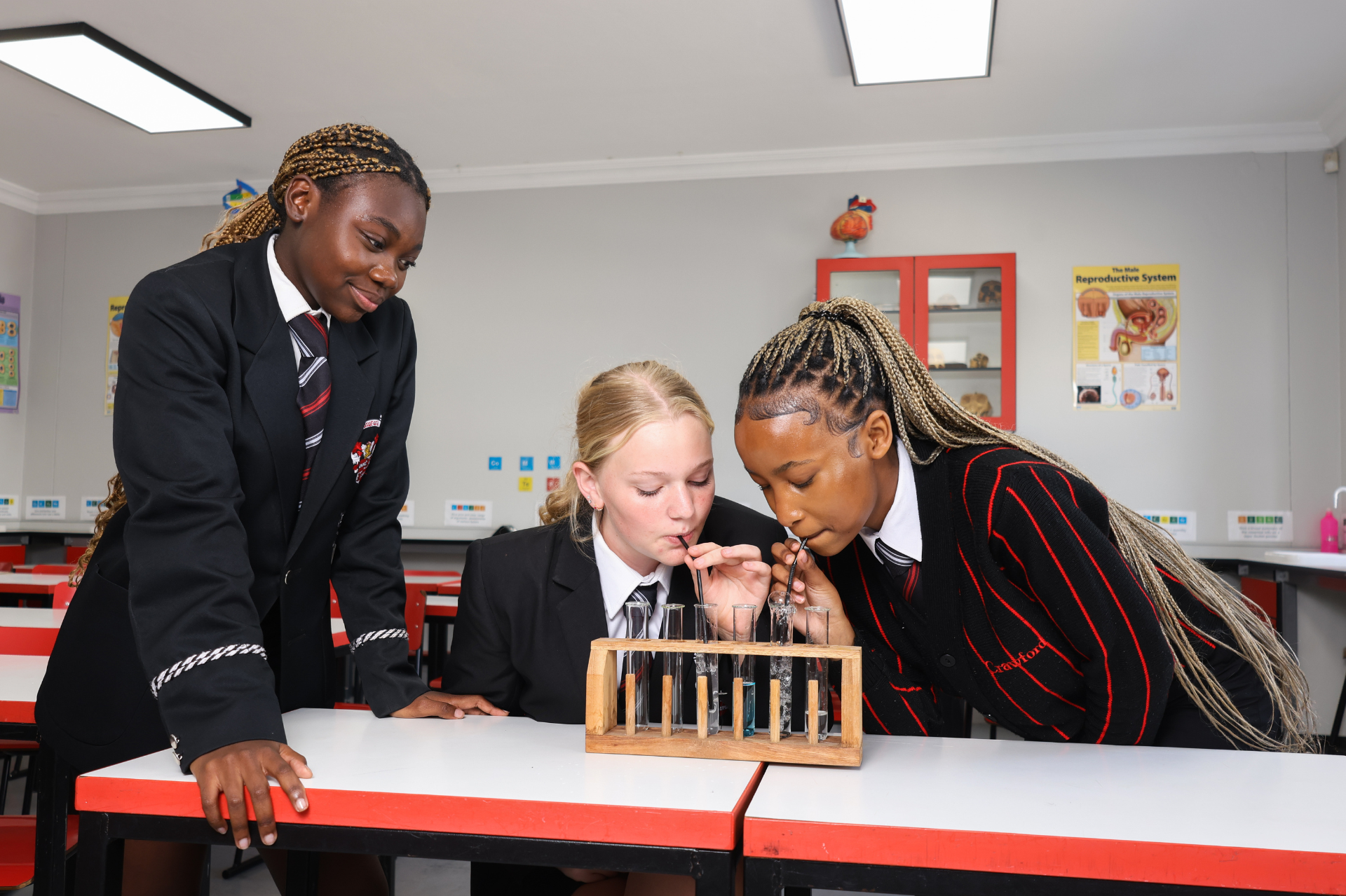a group of children are doing a science experiment in a lab .