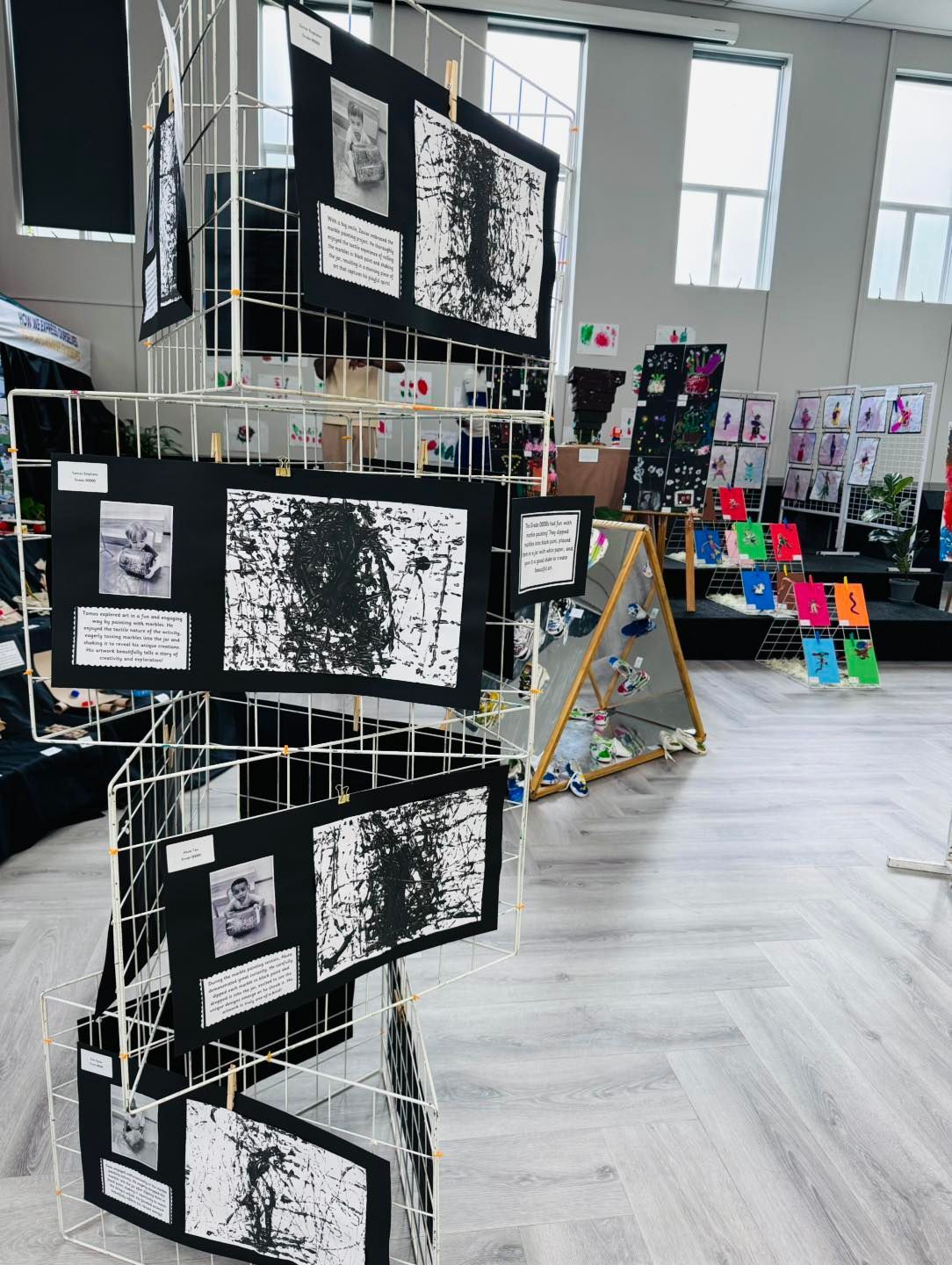 A room filled with lots of paintings and drawings on display.