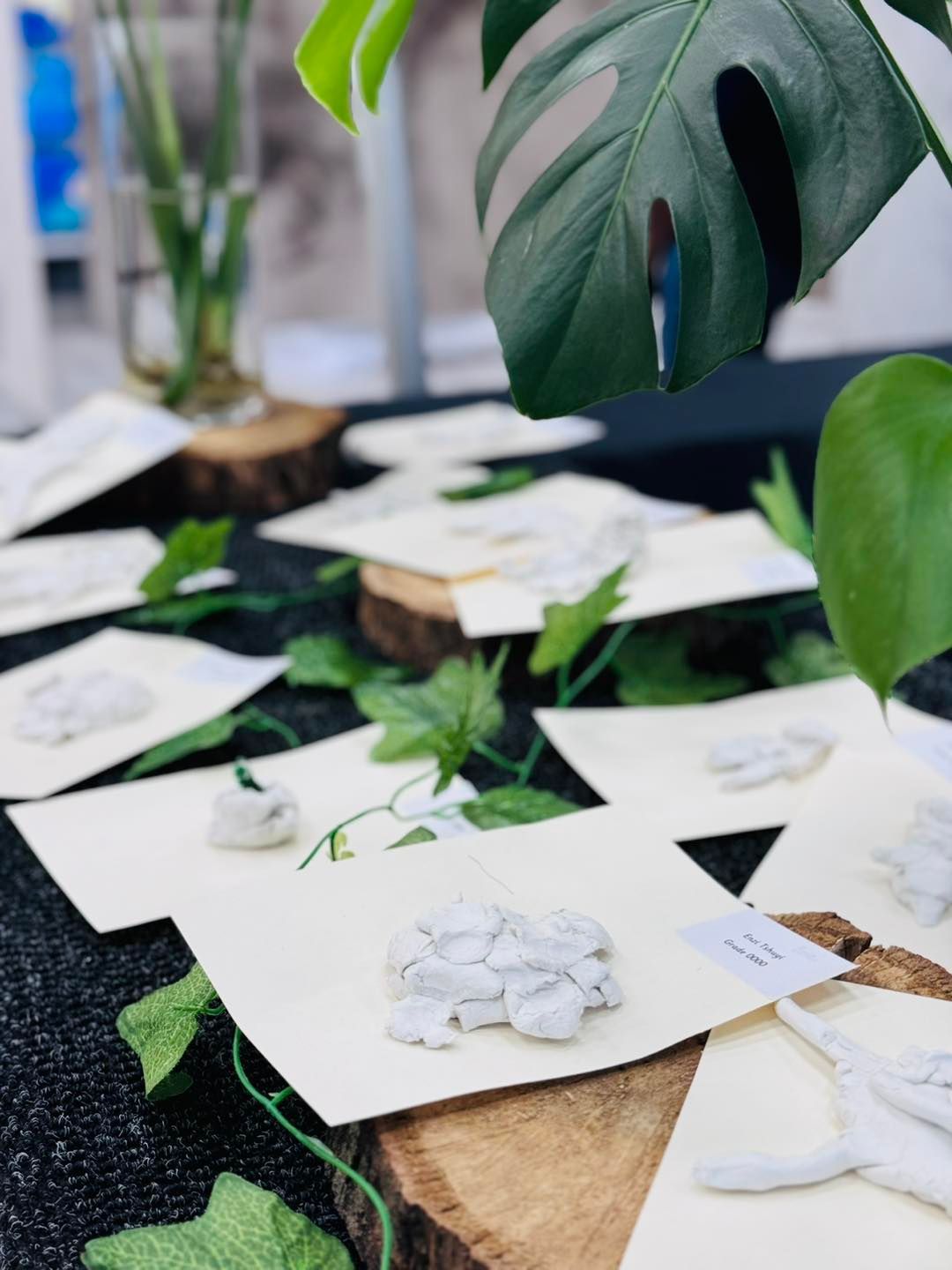 A table with a lot of papers and plants on it