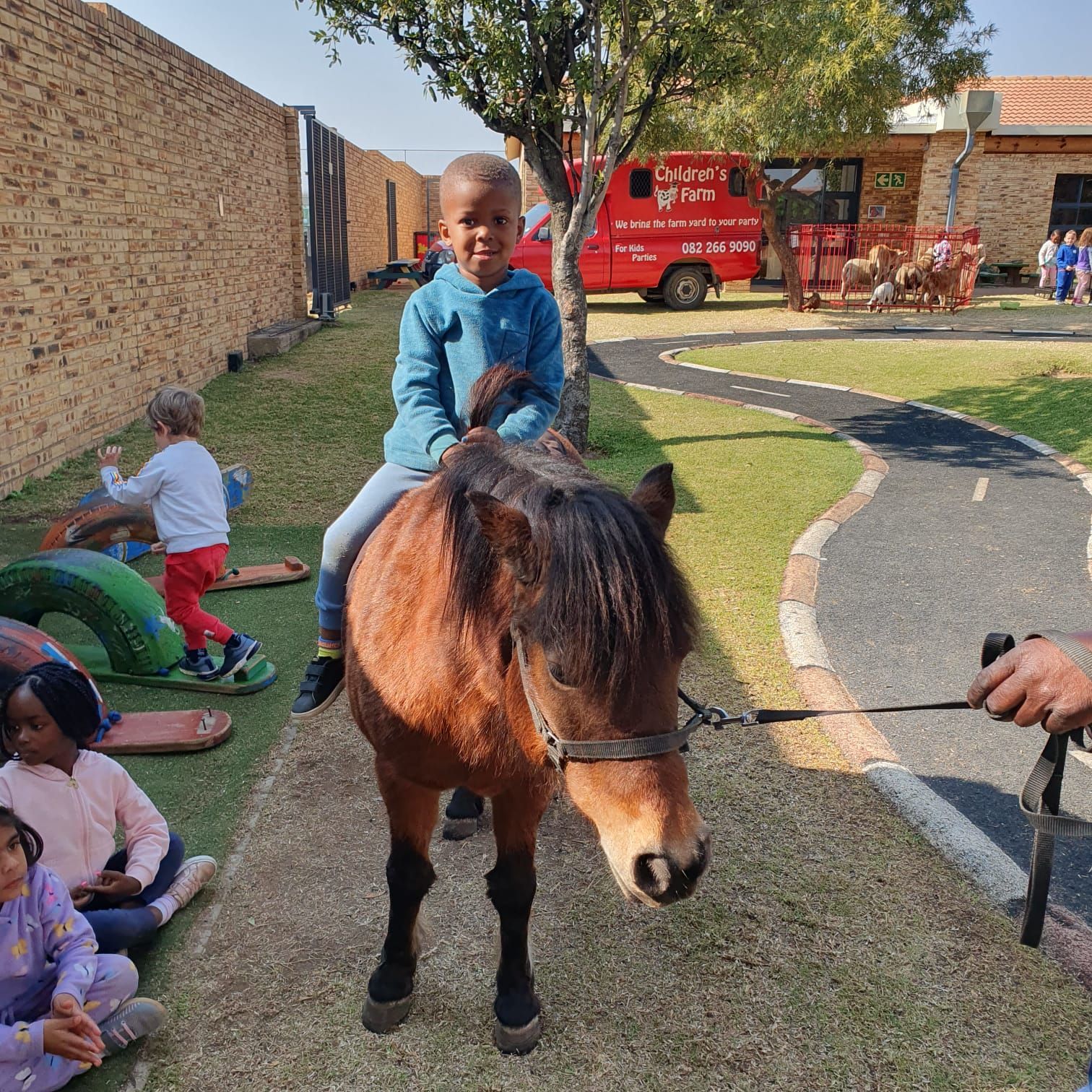 A young boy is riding on the back of a pony.