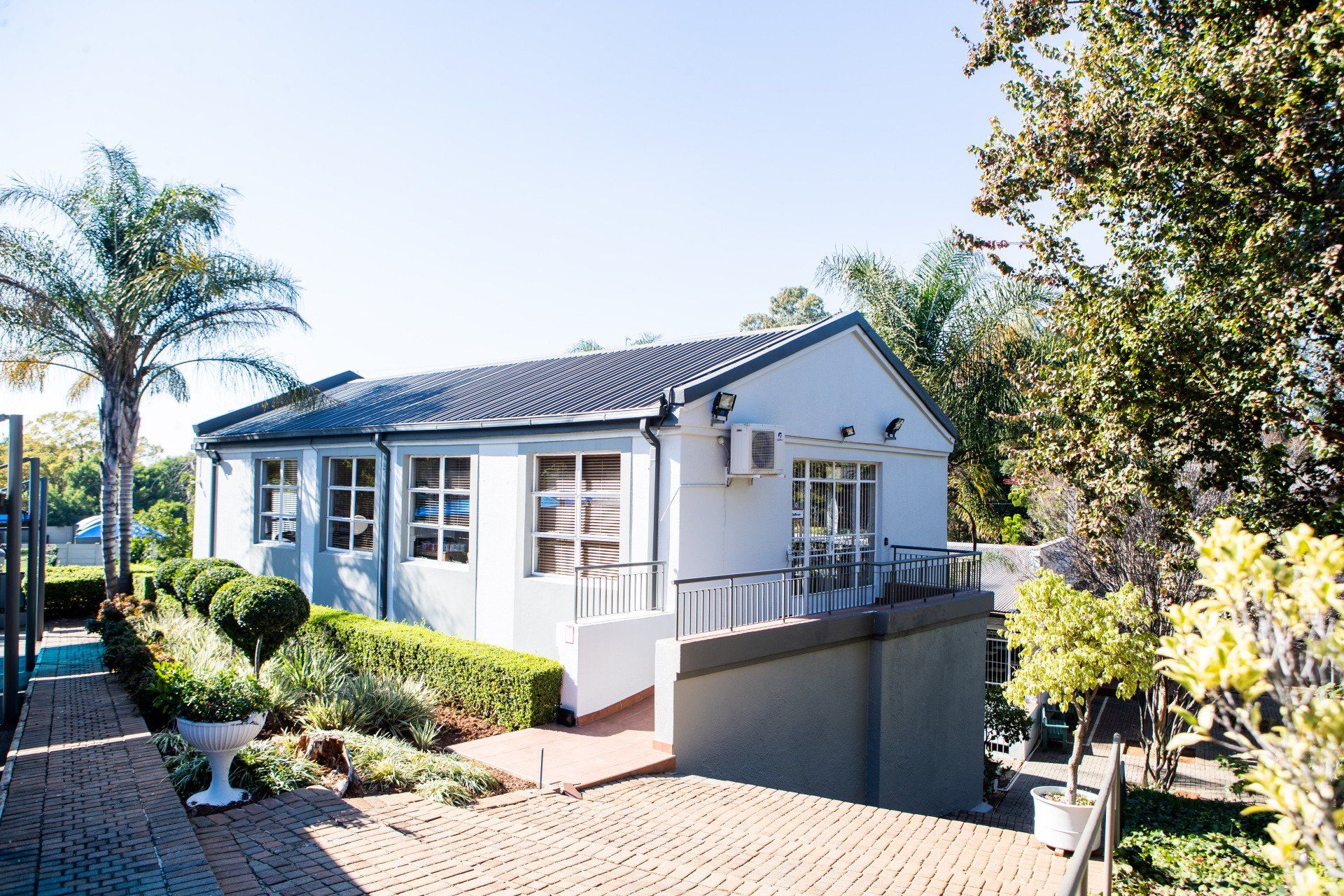 a white house is surrounded by trees and bushes