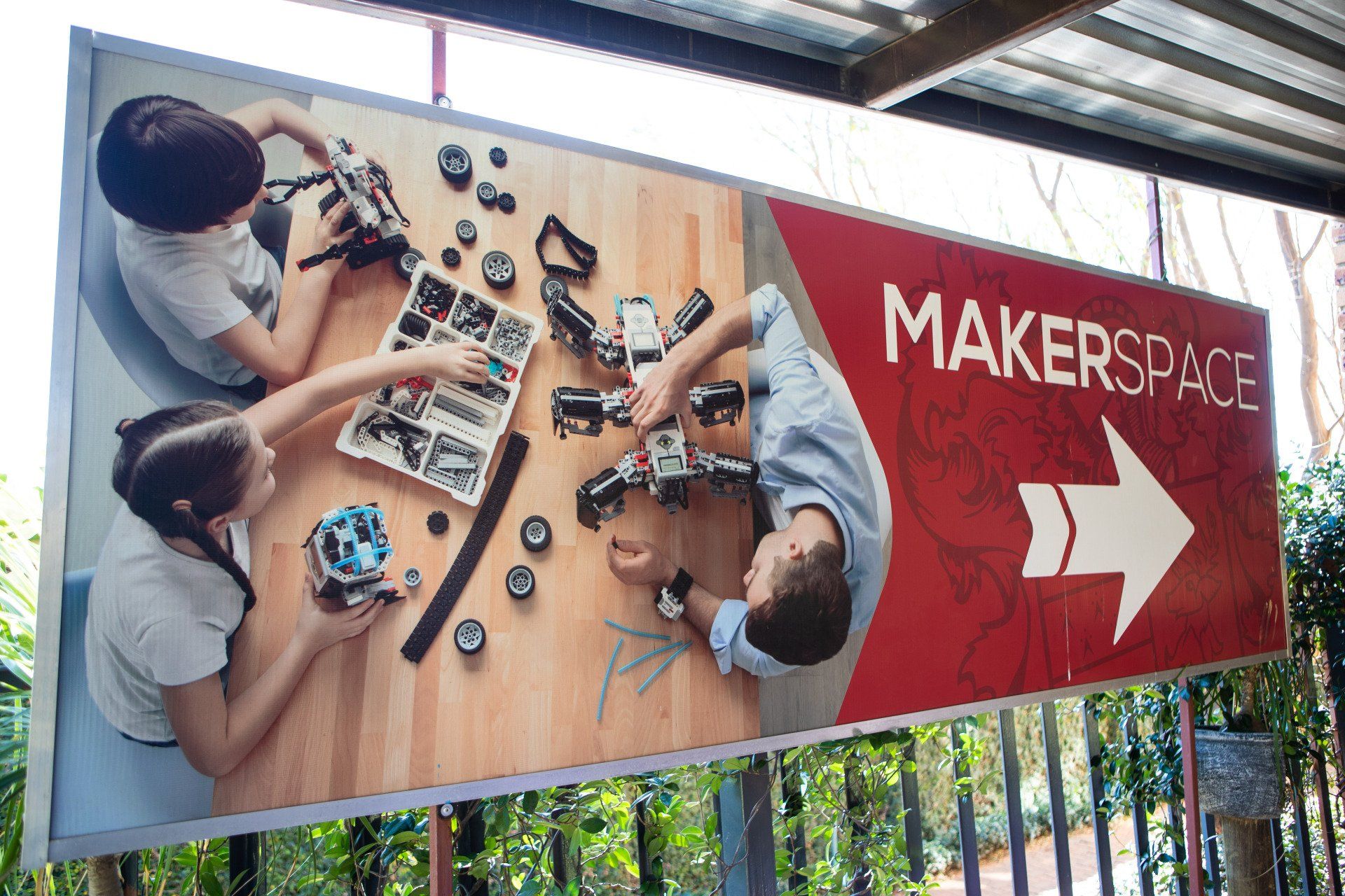 a sign that says makerspace is hanging from a pole
