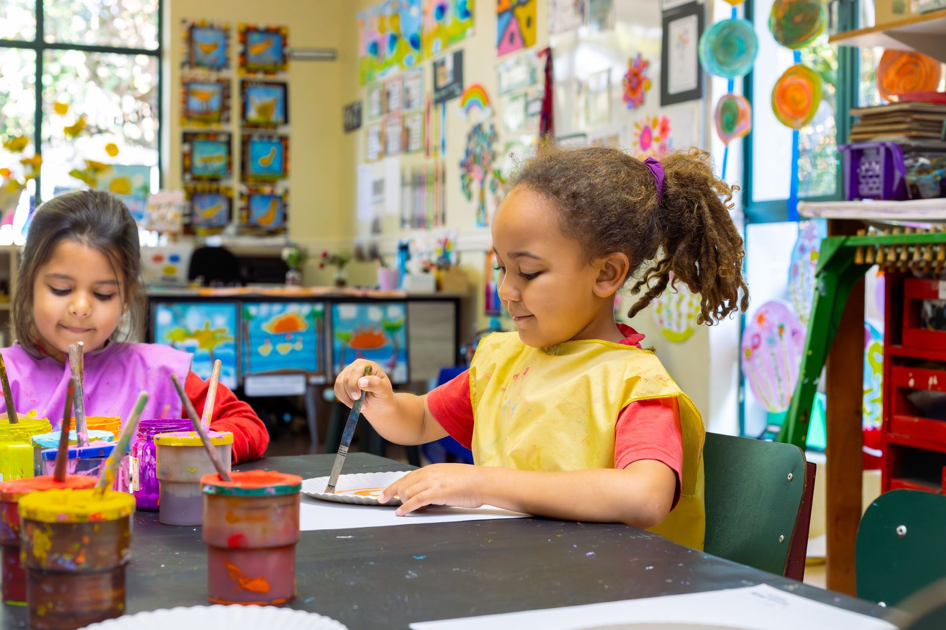 a table topped with buckets of paint and brushes .