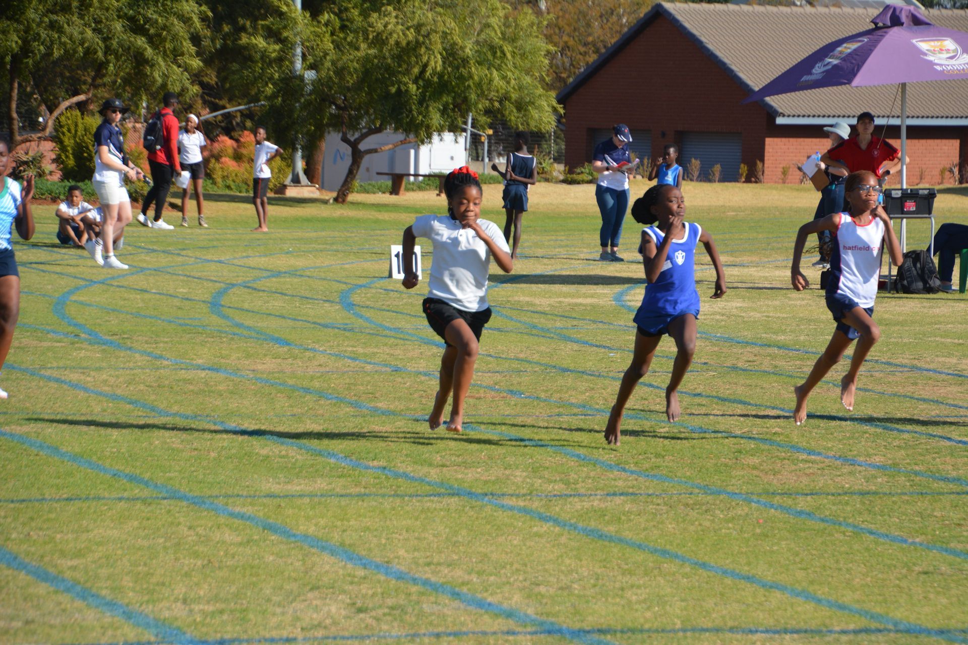 A group of young girls are running on a track.