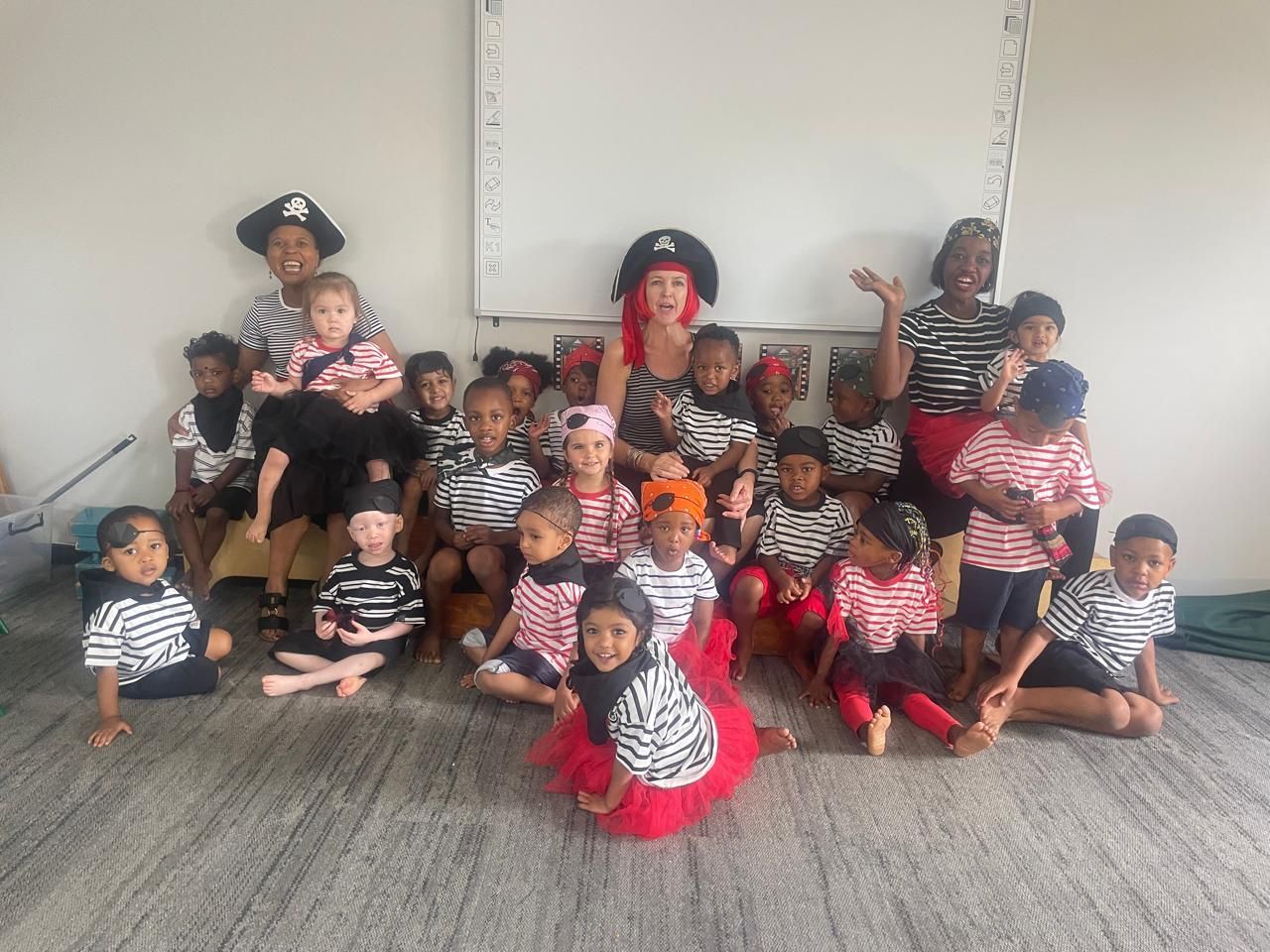 A group of children dressed in pirate costumes are posing for a picture.