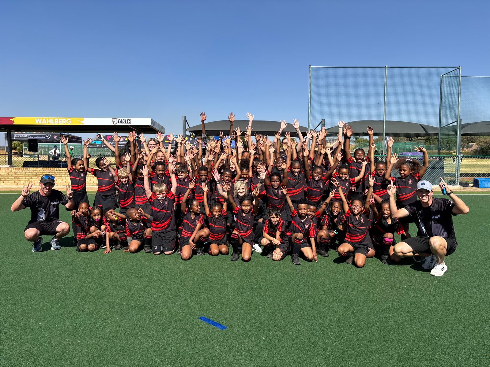 A group of children are posing for a picture on a soccer field.