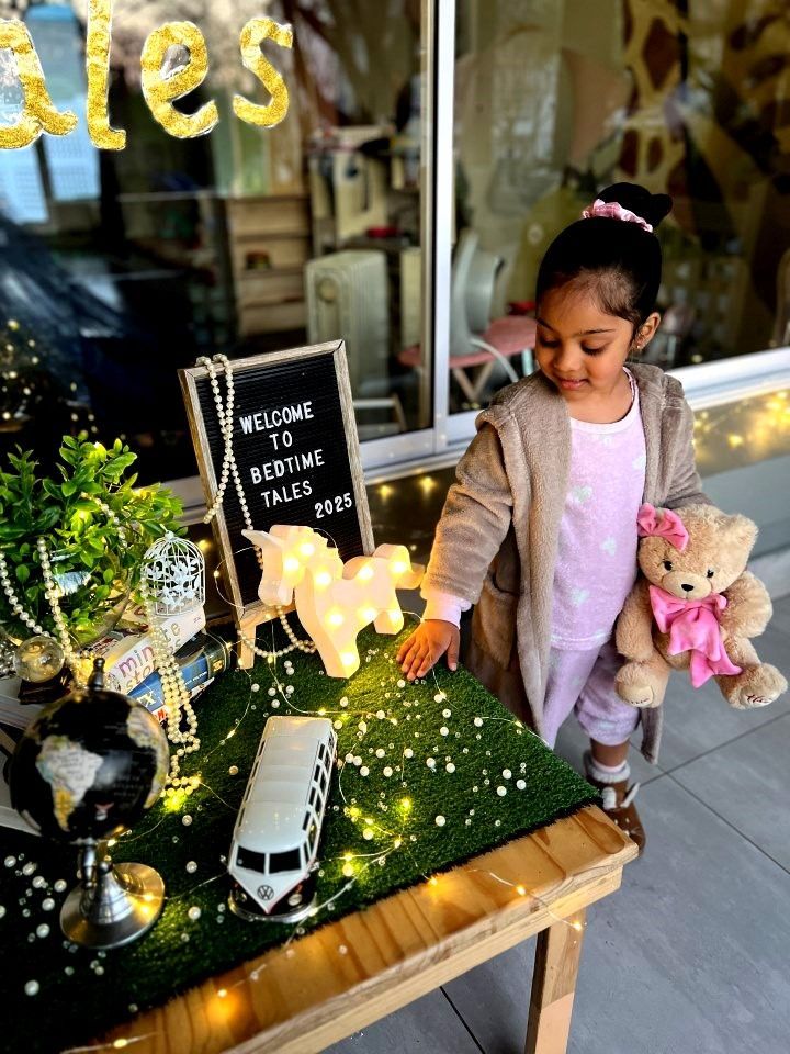 Young child in pajamas at a table with decorations, including a light-up unicorn.