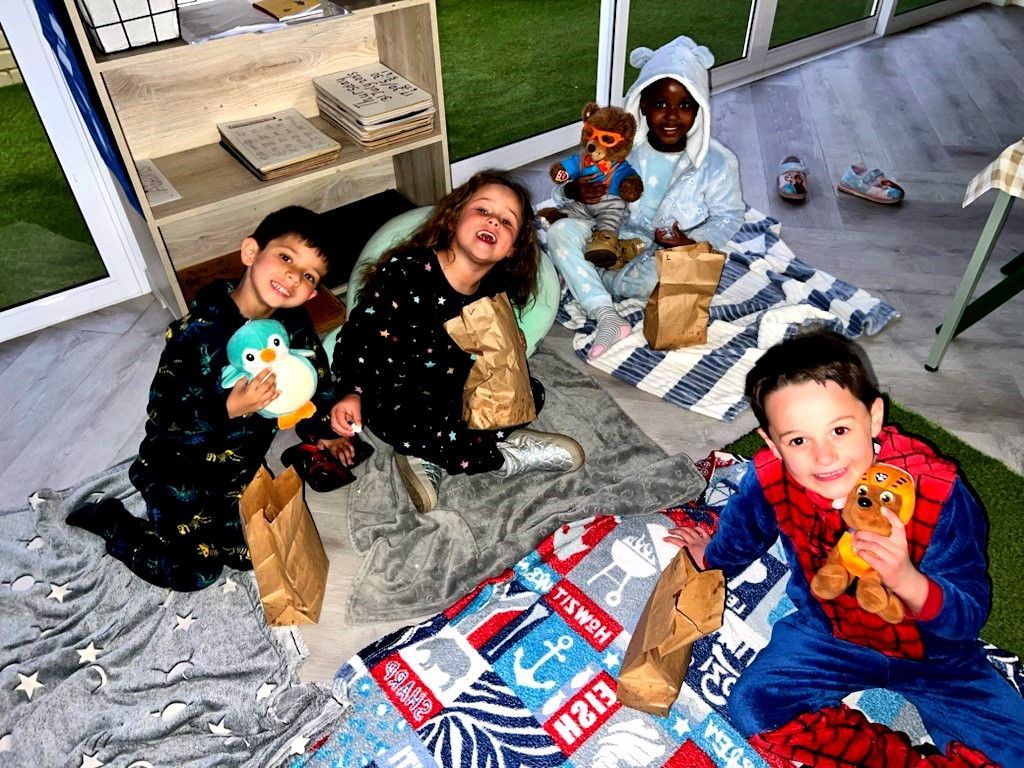 Children in pajamas with snacks and stuffed animals on blankets.