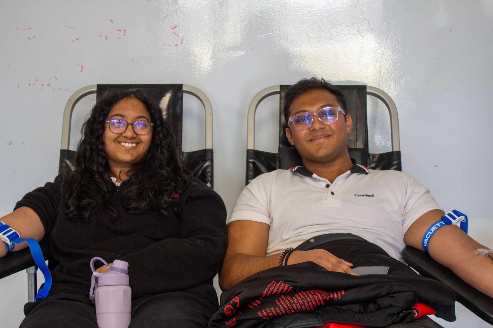 A man and a woman are sitting next to each other in chairs.