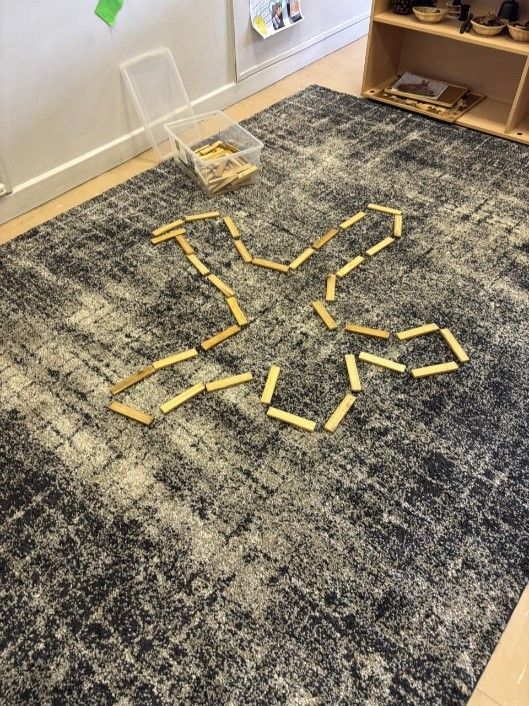 A carpet with a star made out of wooden sticks