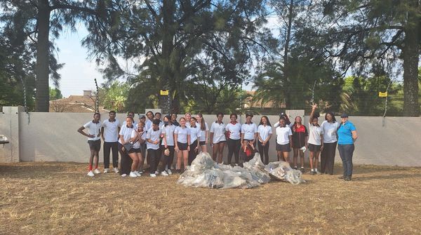 A group of people are posing for a picture in a field.