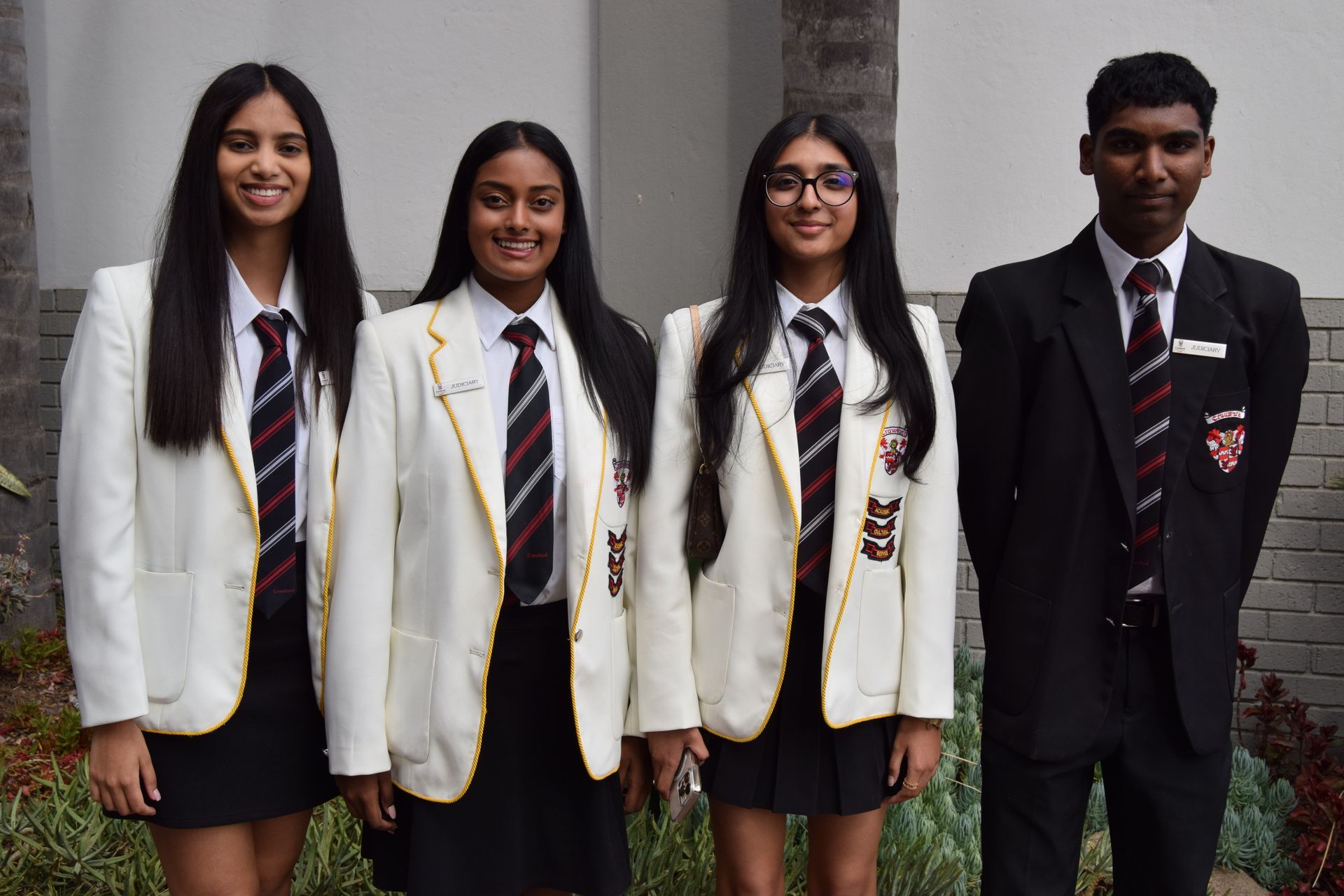 A group of young people in school uniforms and ties are posing for a picture.