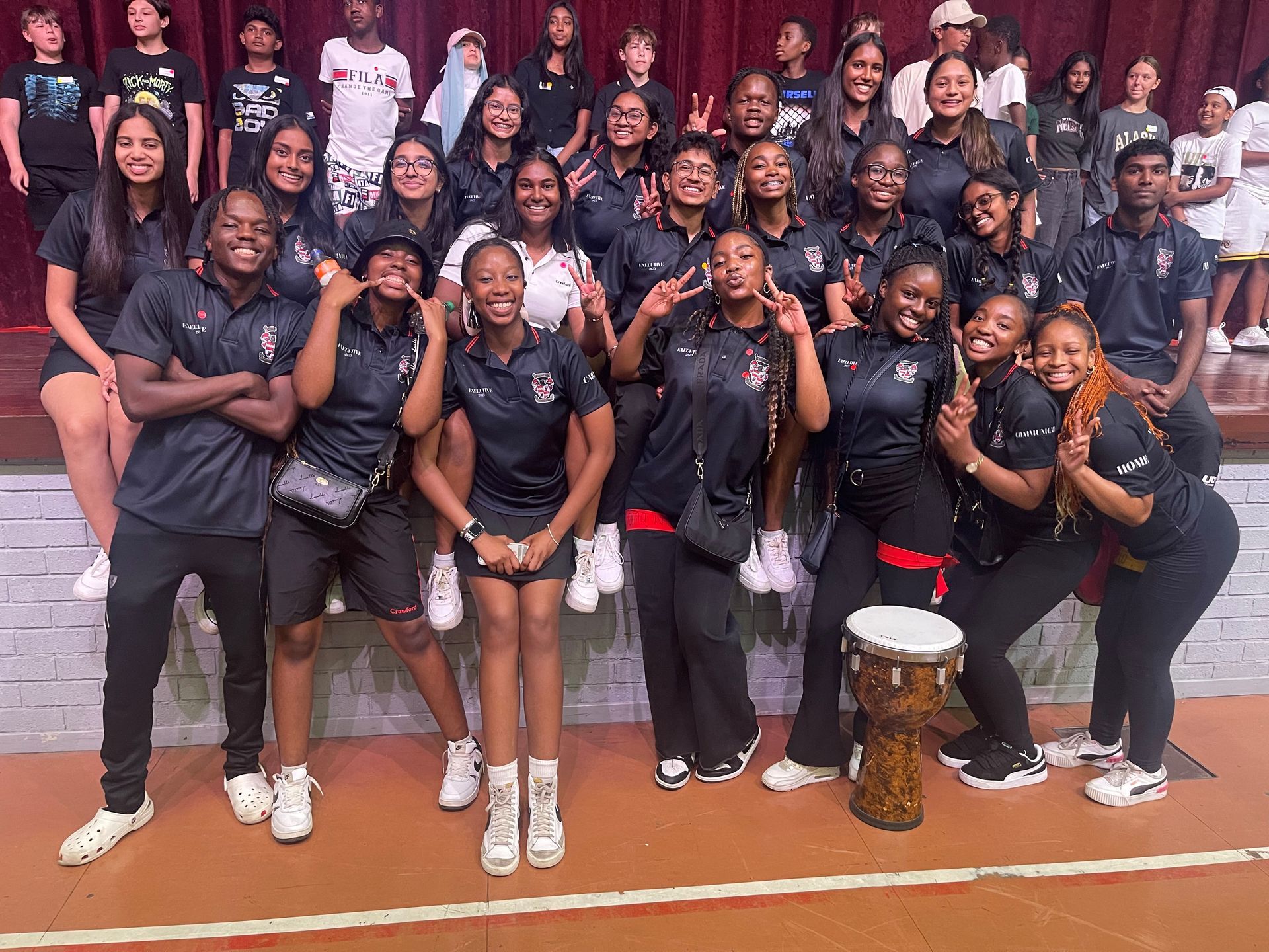 A group of young people are posing for a picture on a stage.