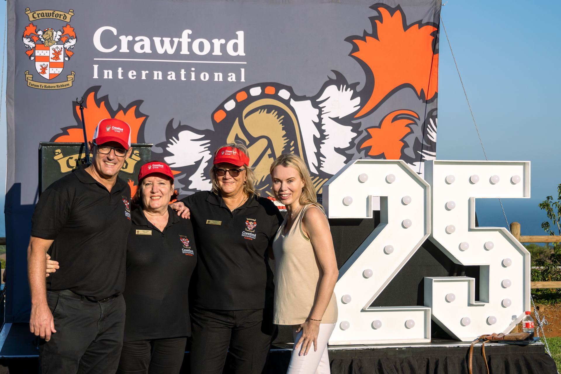 A group of people standing in front of a sign that says 25.