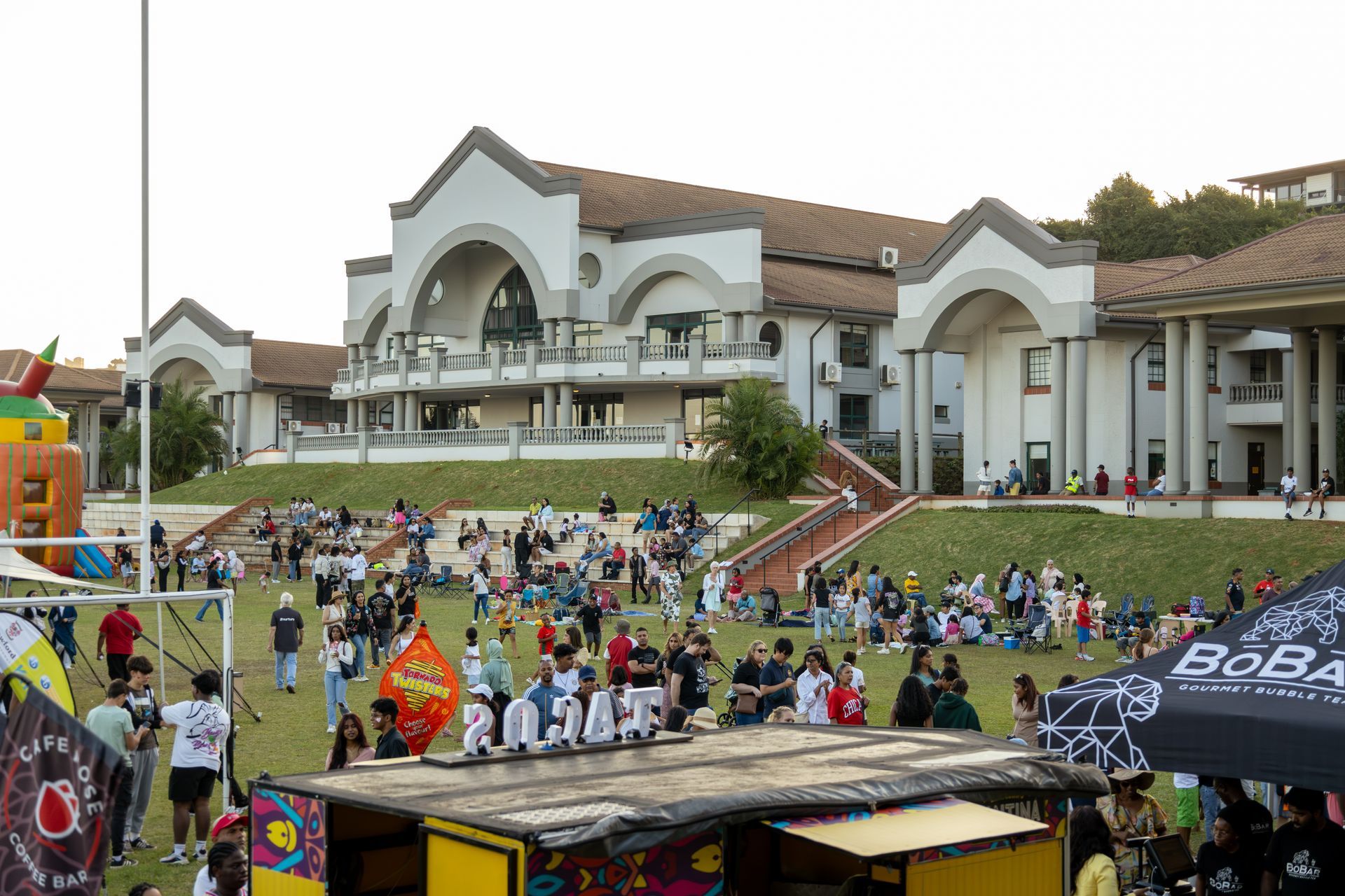 A large group of people are gathered in front of a large building.