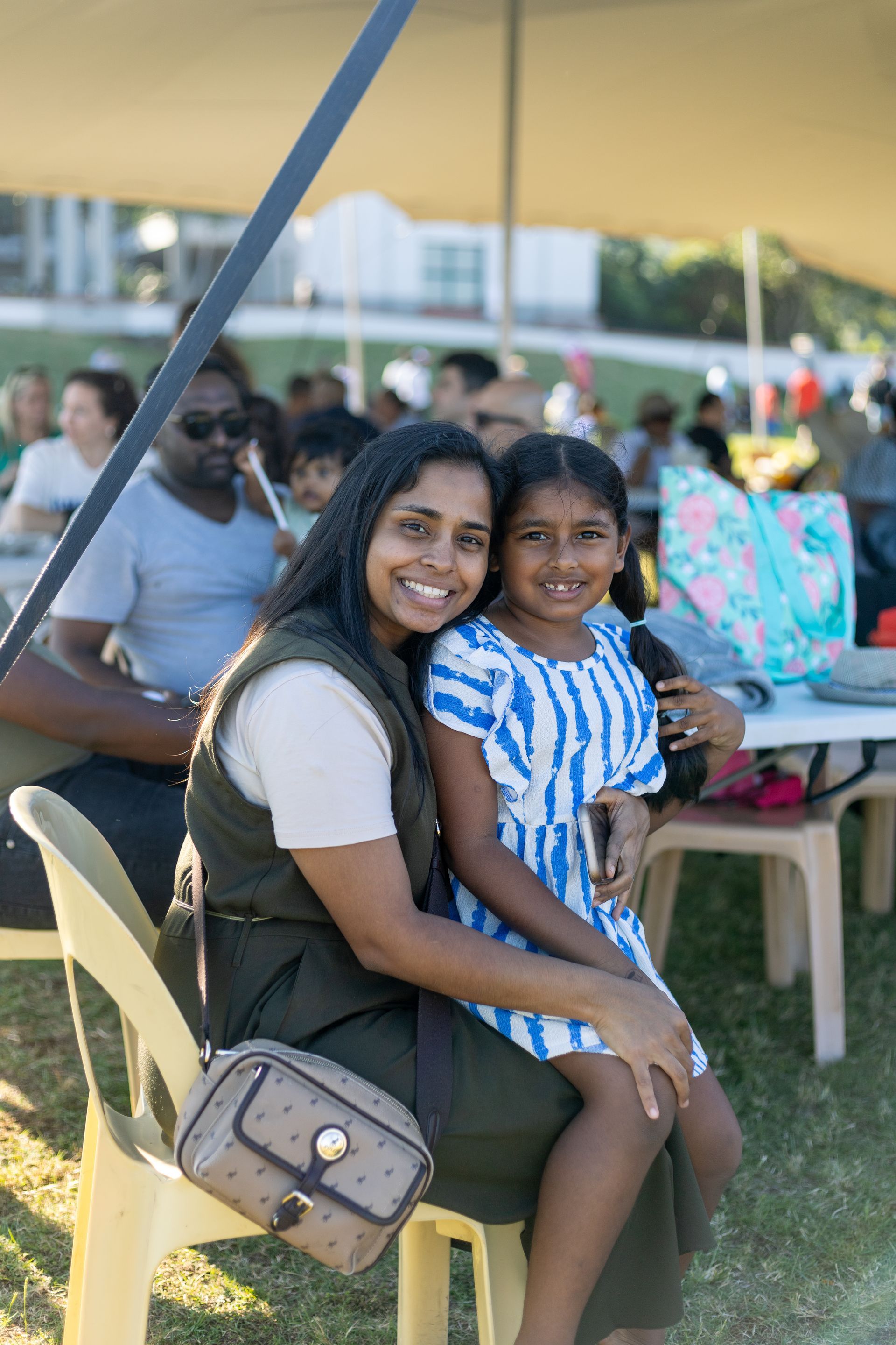 A woman is sitting in a chair with a little girl on her lap.
