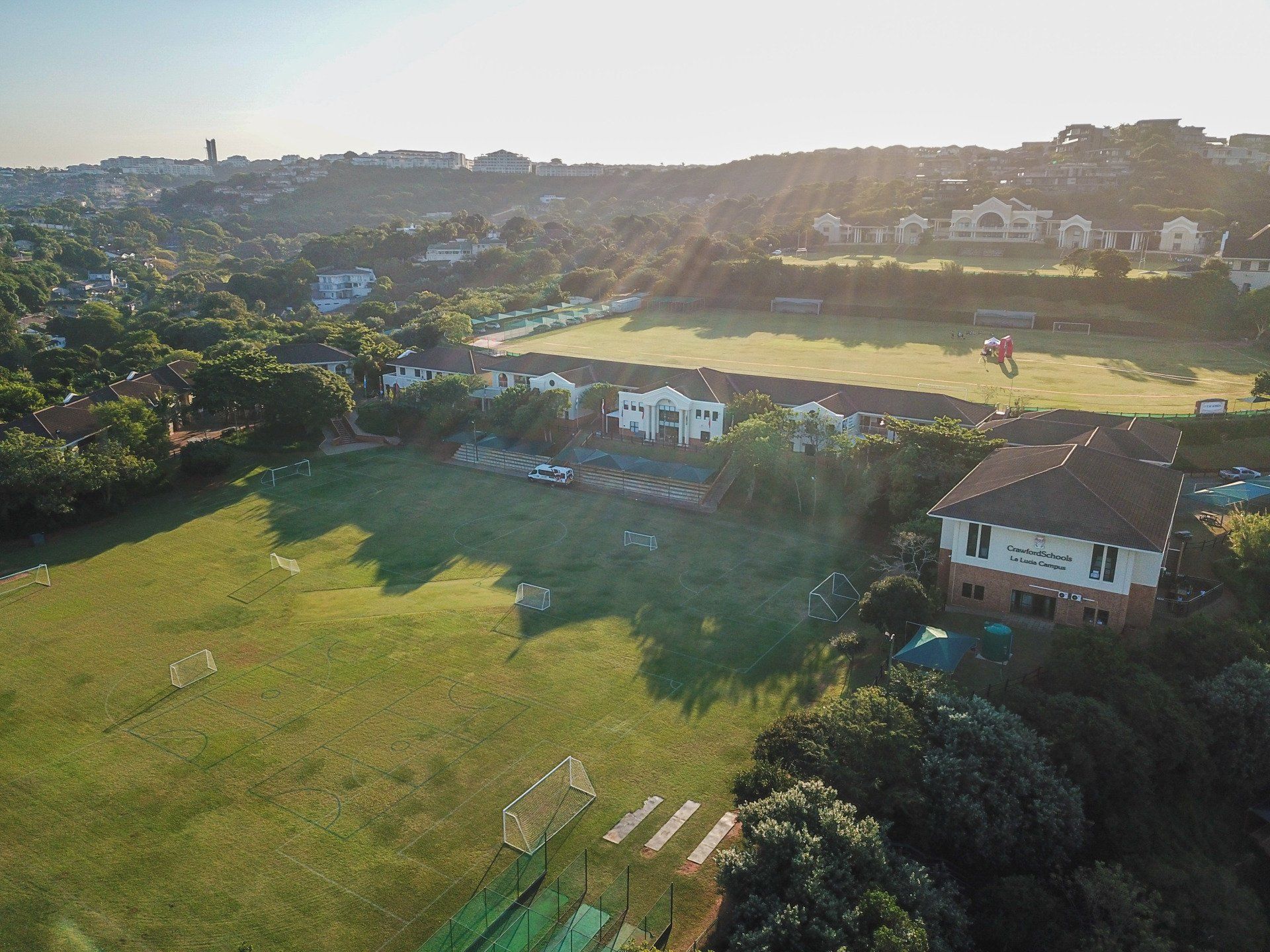 an aerial view of a sport field with a house in the background .