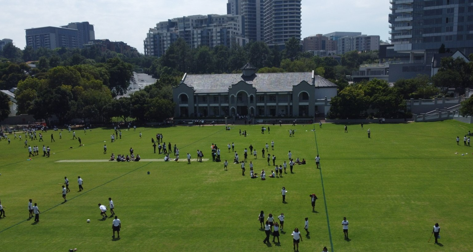 a group of people are playing soccer in a field in front of a building .