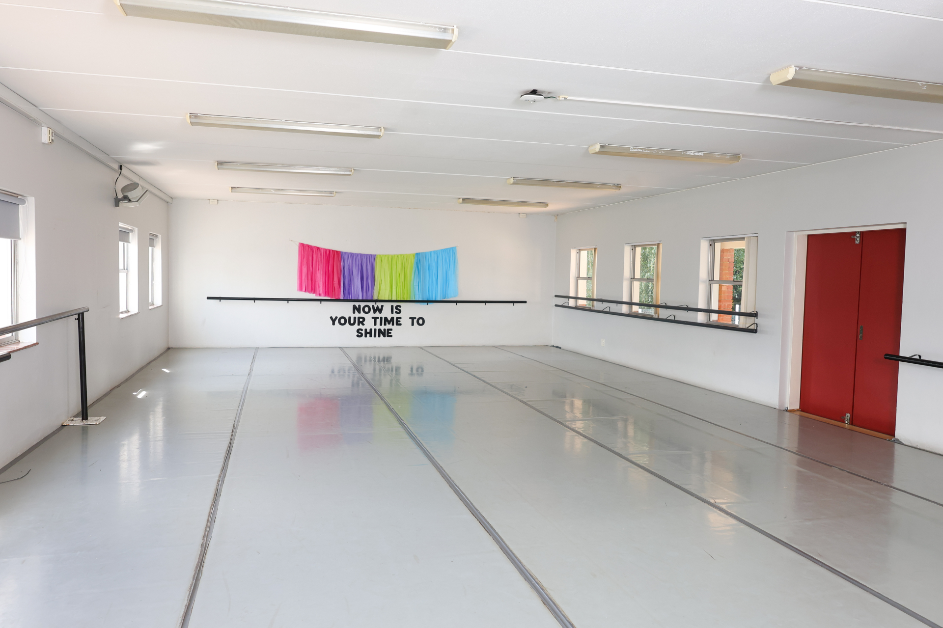 a large room with a stage and glass windows