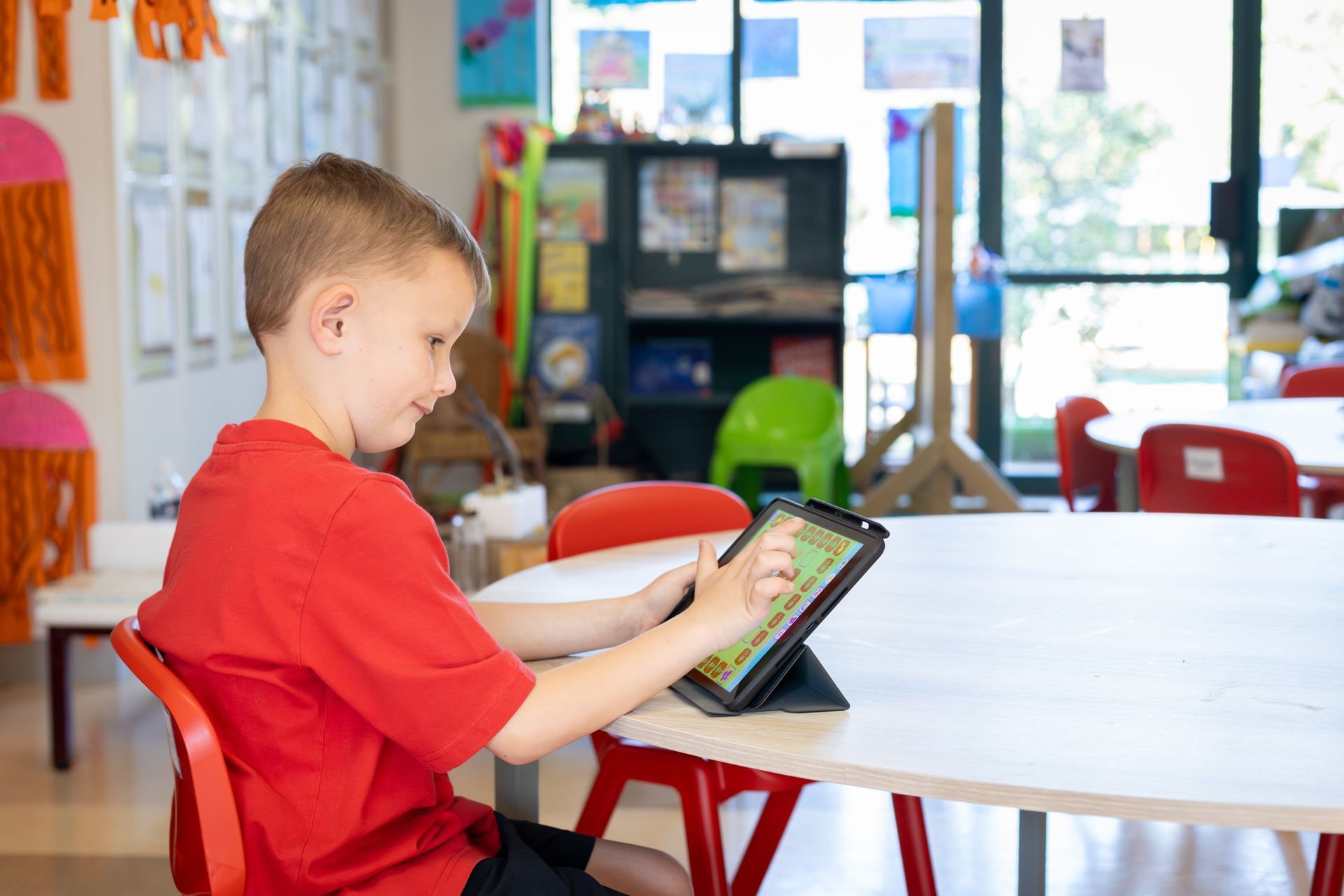 a young girl wearing headphones is using a tablet computer .