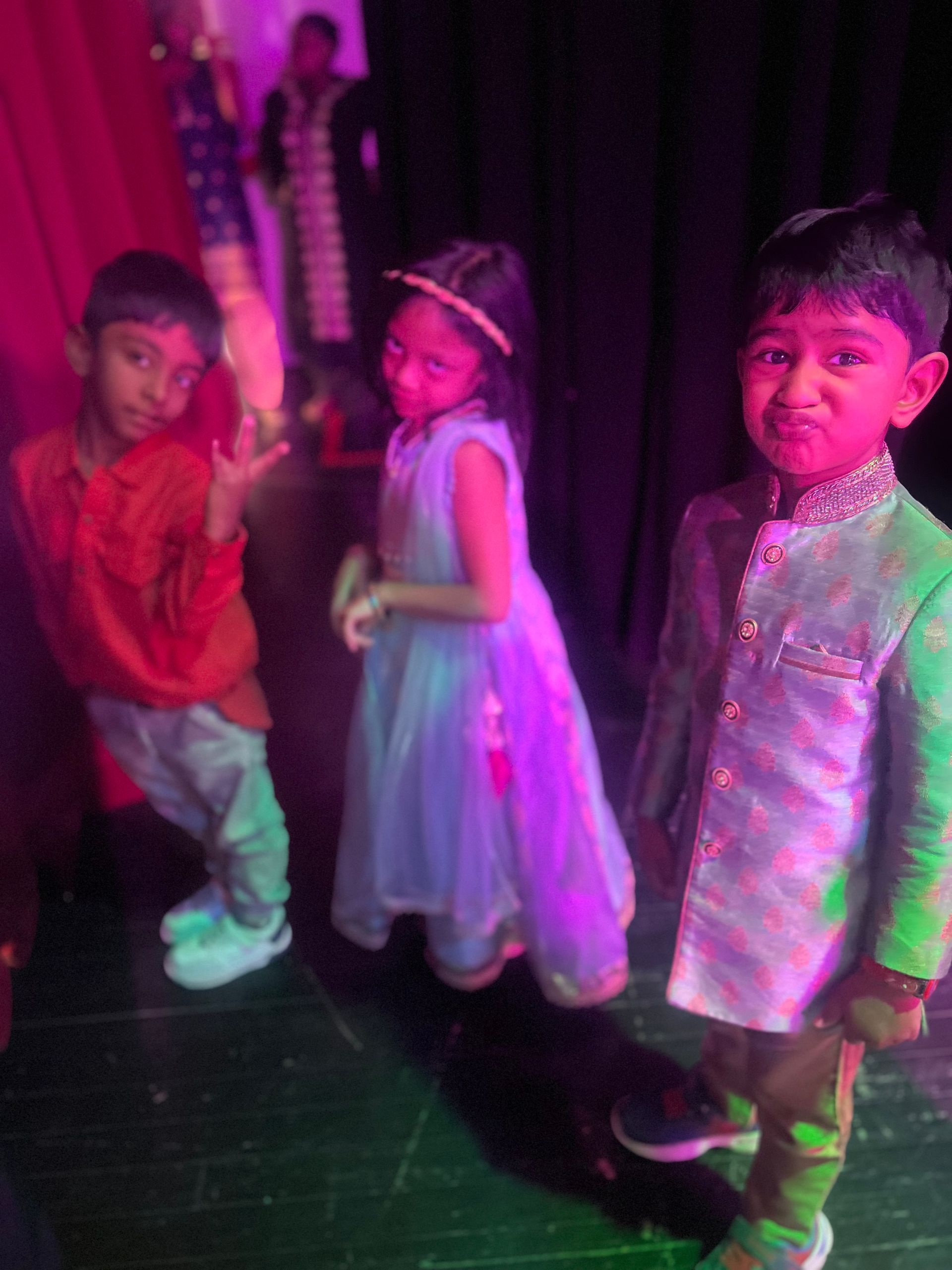 A group of children are standing next to each other on a stage.