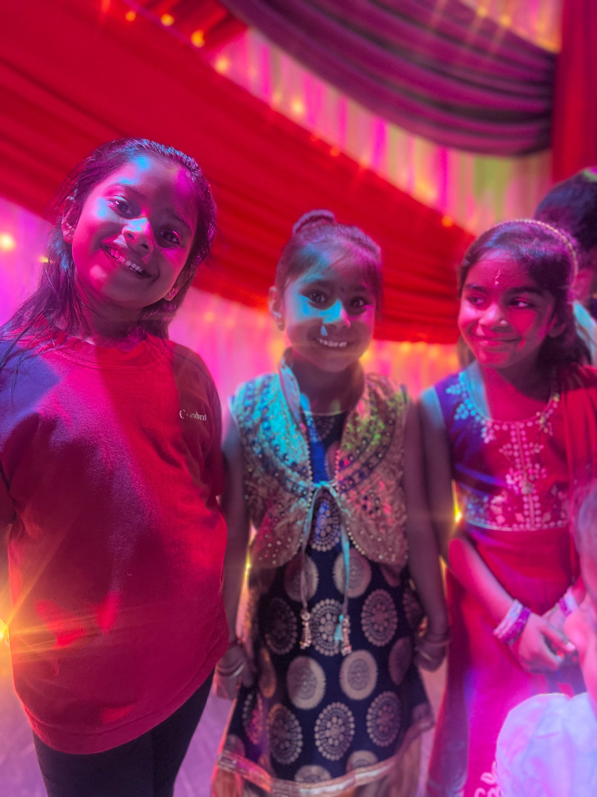 A group of young girls are standing next to each other in a room.