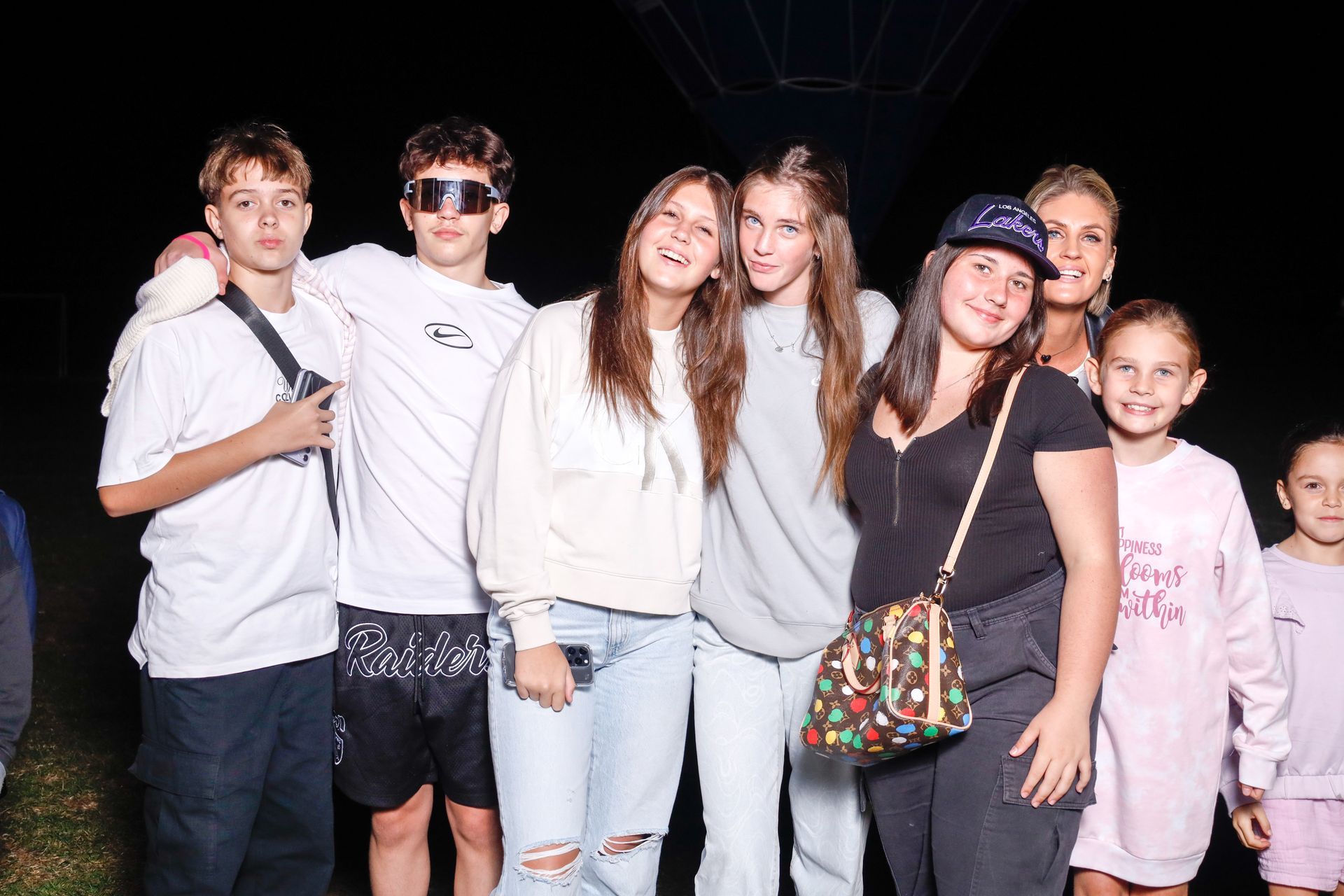 A group of people are posing for a picture together in the dark.