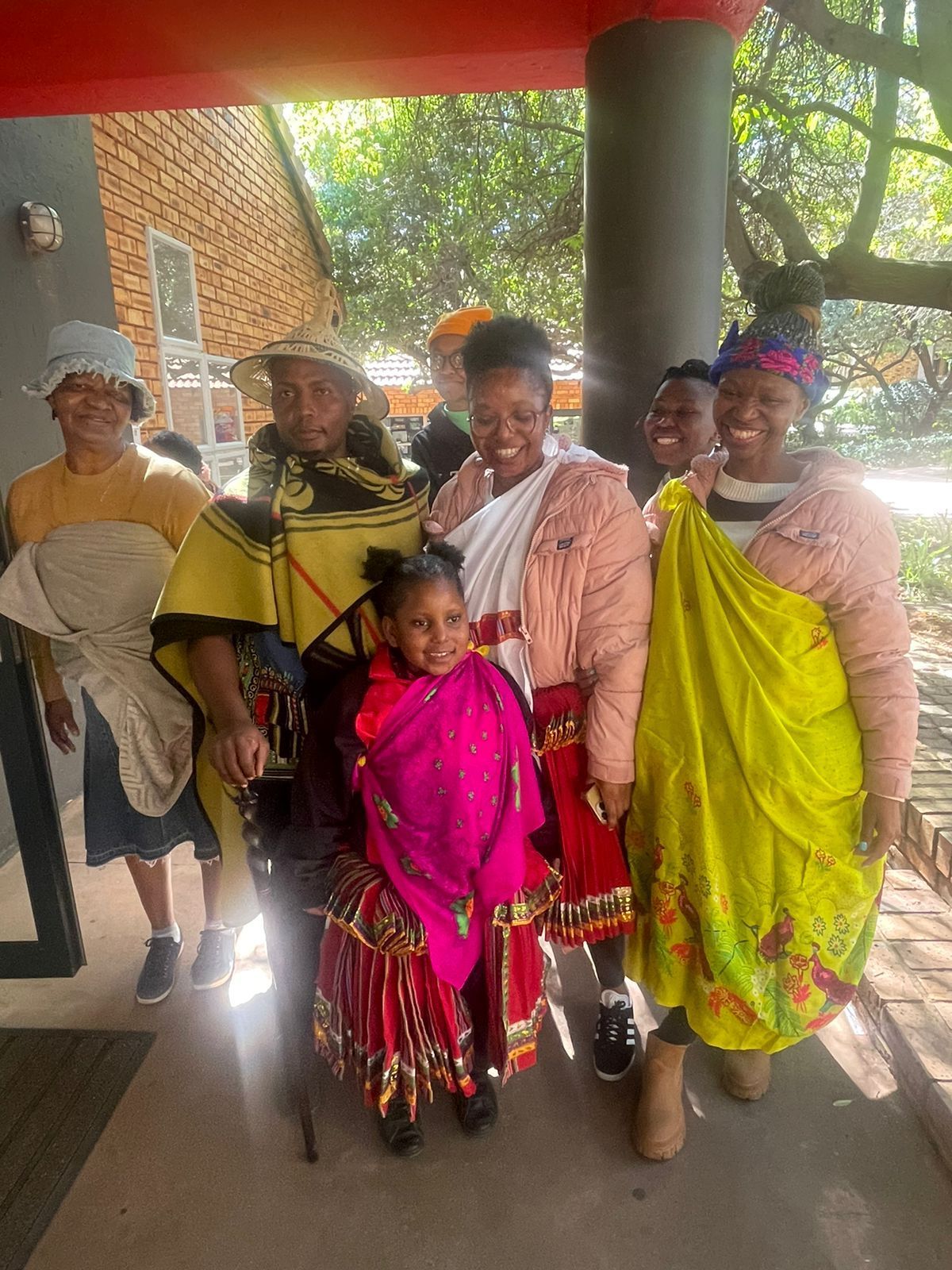 A group of people in traditional clothes are posing for a picture.