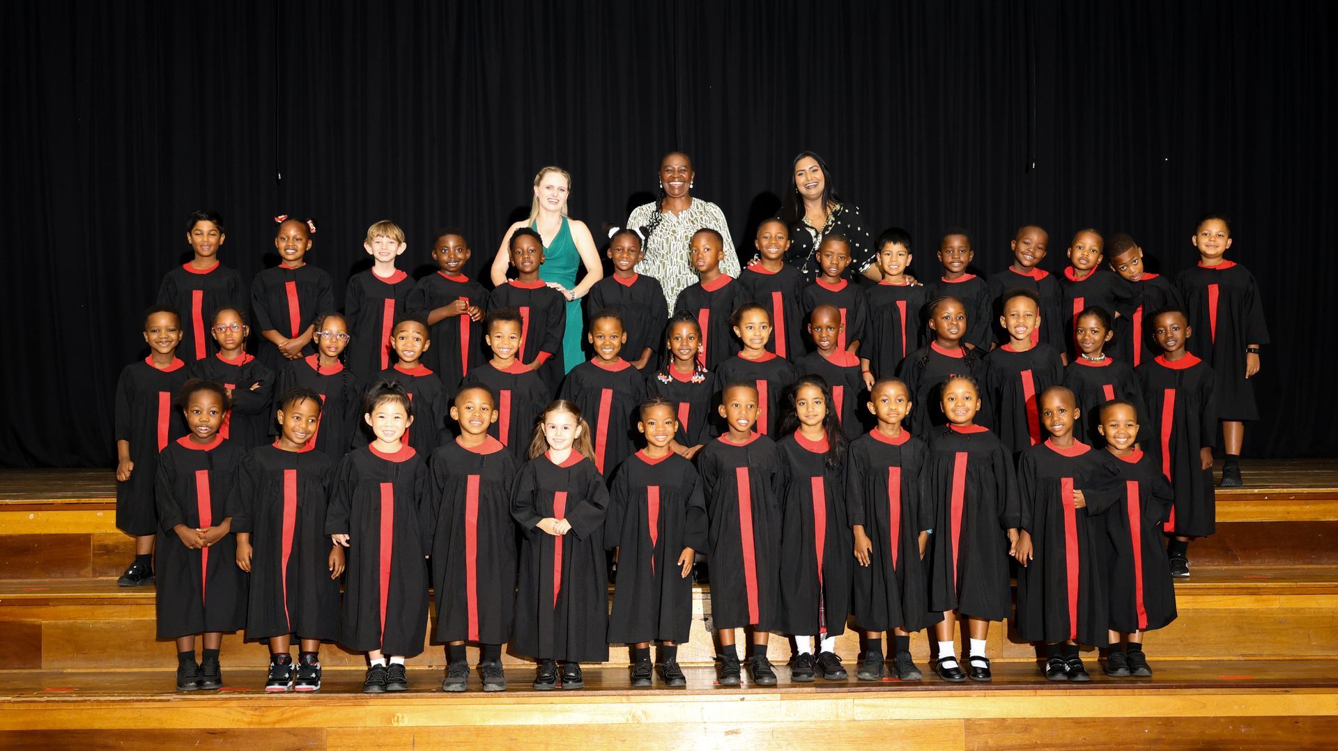 A group of children are posing for a picture on a stage.