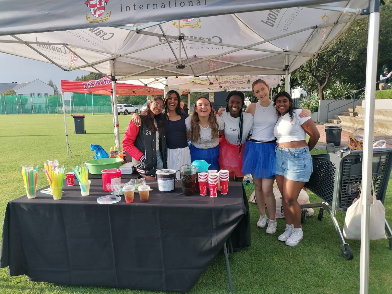 A group of women are posing for a picture in front of a tent.